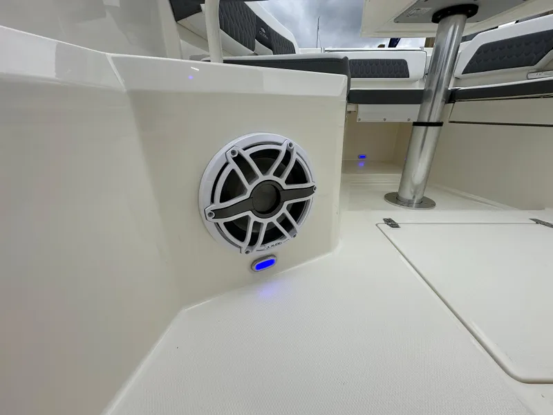 Slide: The Image of 2025 Cobia 265 CC boat interior with speaker and seating area. - 10