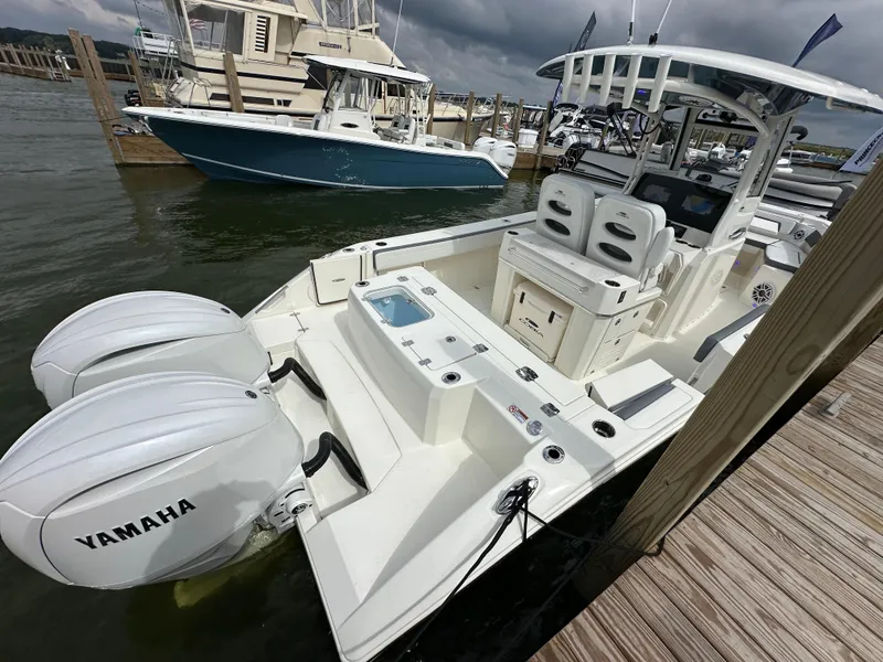 Slide: The Image of 2025 Cobia 265 CC boat with Yamaha engines docked at marina. - 2