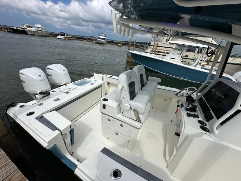 Slide: The Image of 2025 Cobia 265 CC boat with dual Yamaha engines docked at marina. - 3