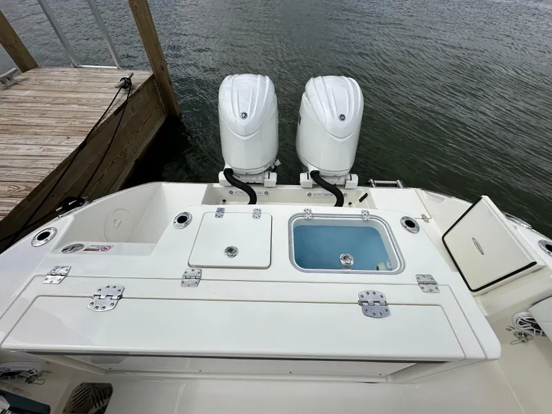 Slide: The Image of 2025 Cobia 265 CC boat with dual engines and fishing amenities at dock. - 5