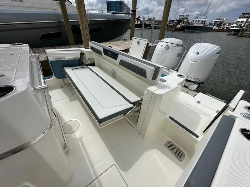 Slide: The Image of 2025 Cobia 265 CC boat interior with foldable seating and twin outboard motors. - 6