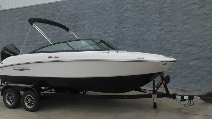 Slide: The Image of 2025 Monterey M-205 boat on trailer, white and black design, parked by gray wall. - 10