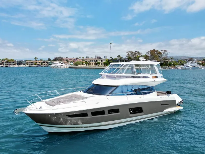 Slide: The Image of 2016 Prestige 550 yacht cruising on a sunny day in a scenic harbor. - 0