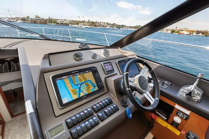 Slide: The Image of Prestige 550 yacht helm with navigation system, 2016 model, overlooking scenic waterfront. - 23