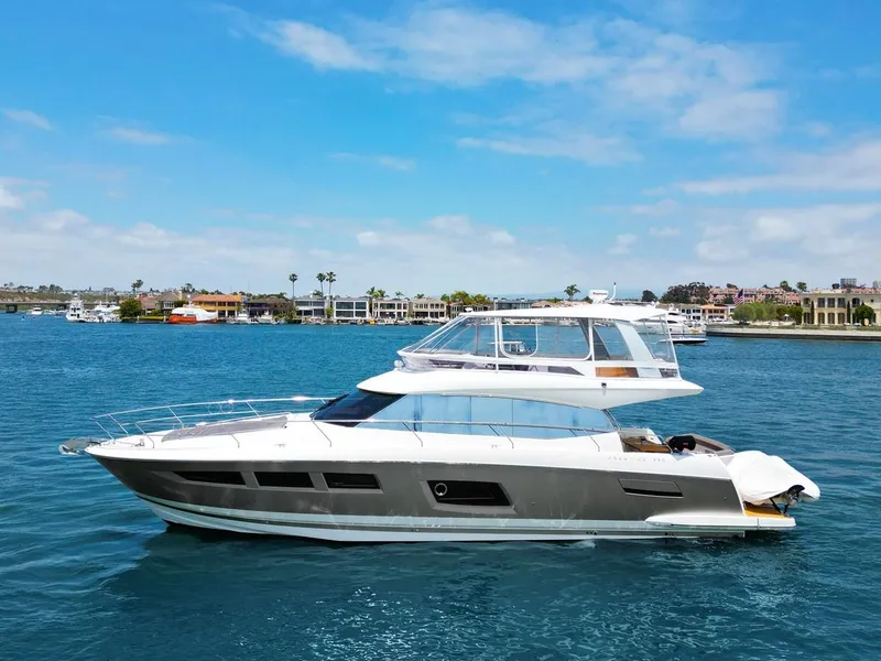 Slide: The Image of 2016 Prestige 550 yacht cruising on a sunny day in a scenic harbor. - 44