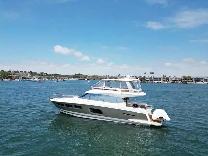 Slide: The Image of 2016 Prestige 550 yacht cruising on a sunny day in a scenic harbor. - 45