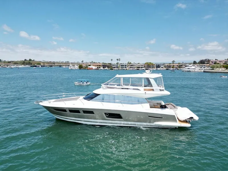 Slide: The Image of 2016 Prestige 550 yacht cruising on a sunny day in a scenic harbor. - 46