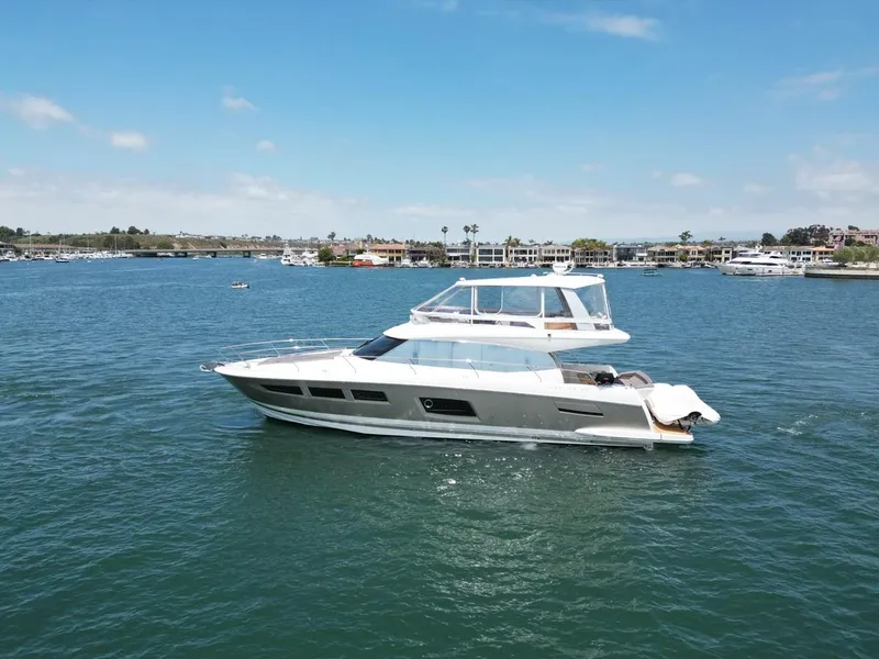 Slide: The Image of 2016 Prestige 550 yacht cruising on a sunny day in a scenic harbor. - 47