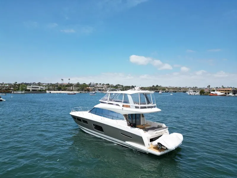 Slide: The Image of 2016 Prestige 550 yacht cruising on a sunny day in a scenic harbor. - 49
