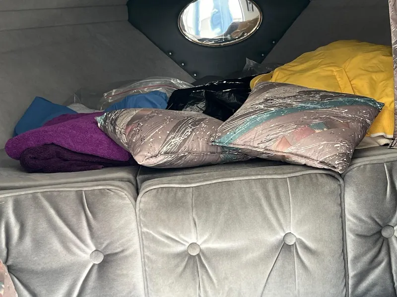 Slide: The Image of Interior cabin of 1994 Checkmate 253 Convincor with cushions and colorful blankets. - 16