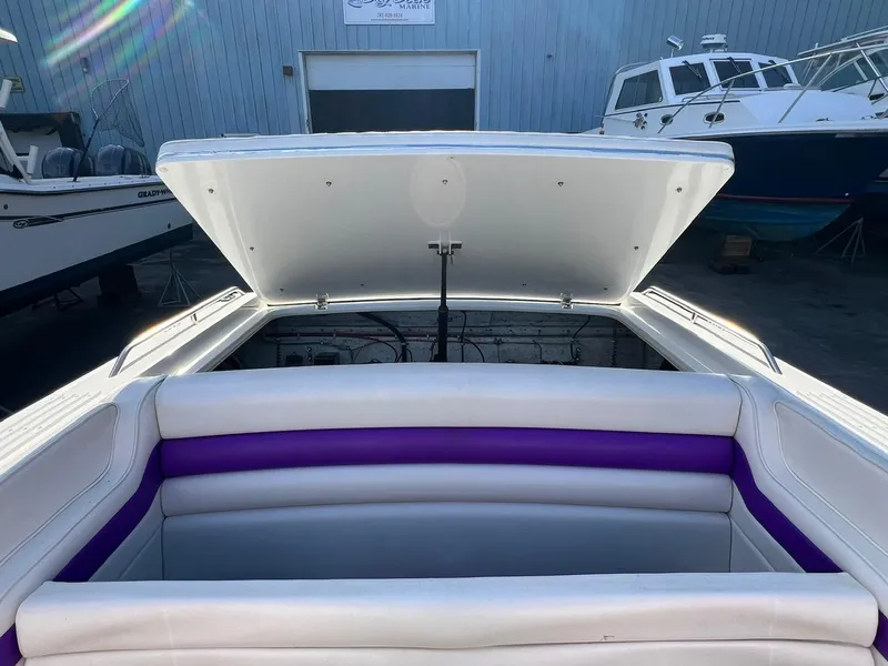 Slide: The Image of 1994 Checkmate 253 Convincor boat interior with open engine compartment, white and purple seating. - 19