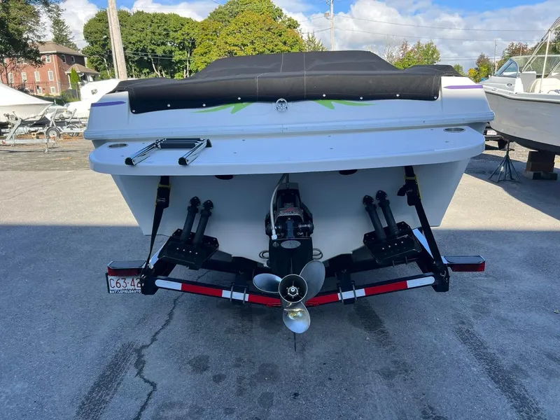 Slide: The Image of 1994 Checkmate 253 Convincor boat, rear view, parked on concrete, with covered deck. - 6