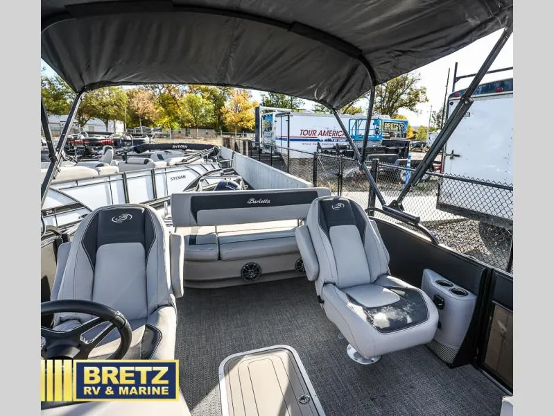 Slide: The Image of 2025 Aria Cast-N-Cruise A22CC boat interior with seating, canopy, and steering wheel at Bretz RV & Marine. - 24