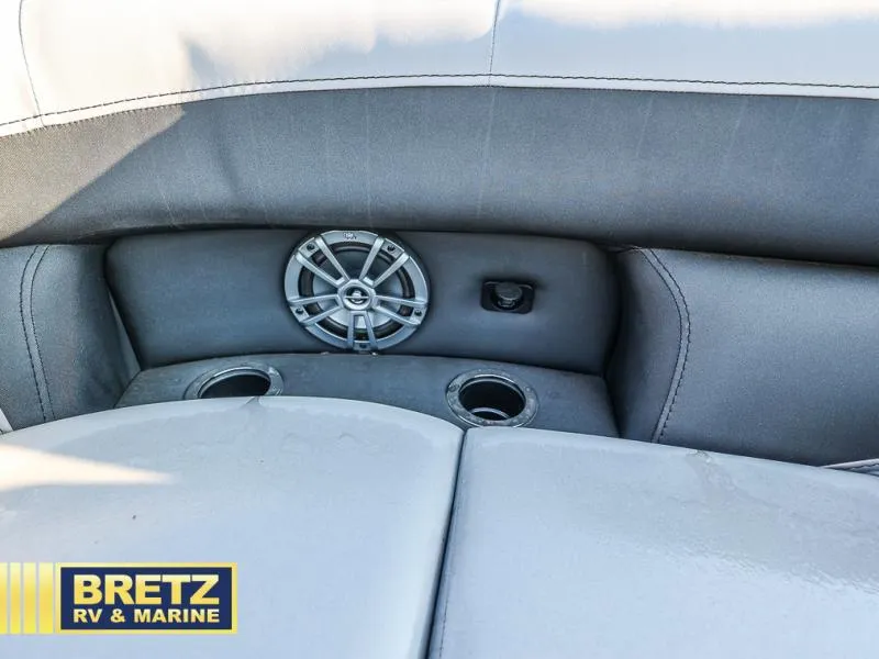 Slide: The Image of Aria Cast-N-Cruise A22CC 2025 boat interior with speaker and cup holders. - 33