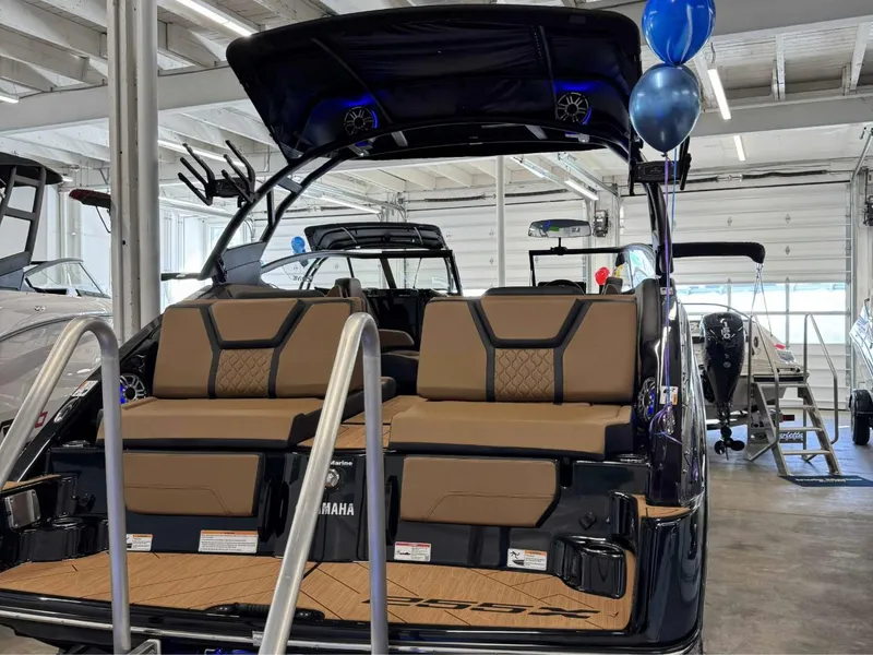 Slide: The Image of 2025 Yamaha Boats 255XD interior with tan seating, showcased in a showroom. - 5