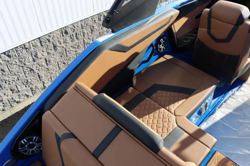 Slide: The Image of 2025 Yamaha Boats 222XD interior with tan and black seating, blue accents, and speakers. - 10