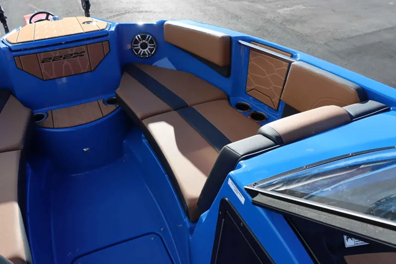 Slide: The Image of 2025 Yamaha Boats 222XD interior with blue and brown seating, cup holders, and speaker. - 17