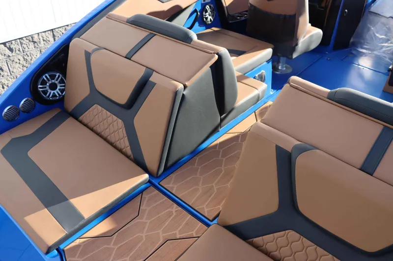 Slide: The Image of 2025 Yamaha Boats 222XD interior with tan and black seating, blue accents, and speakers. - 33