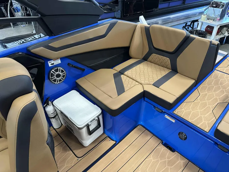 Slide: The Image of 2025 Yamaha Boats 222XE interior with tan and black seating, blue accents, and wood-style flooring. - 11