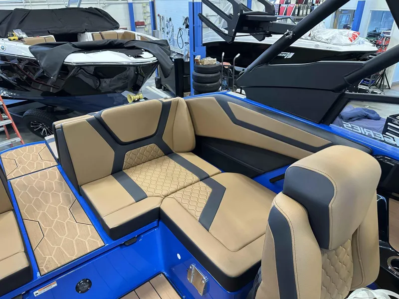 Slide: The Image of 2025 Yamaha Boats 222XE interior with tan and black seating in a showroom. - 12