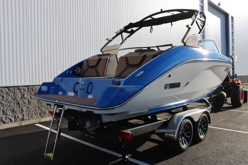 Slide: The Image of 2025 Yamaha Boats 222XE on trailer, blue and white design, parked outdoors. - 4