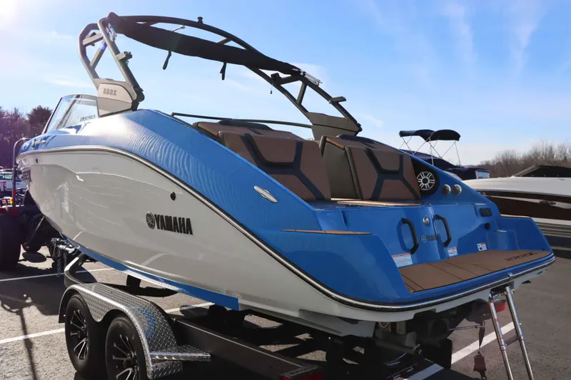 Slide: The Image of 2025 Yamaha Boats 222XE in blue, displayed on a trailer under clear skies. - 5