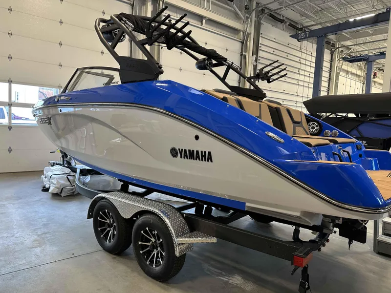 Slide: The Image of 2025 Yamaha Boats 222XE in showroom, blue and white design on trailer. - 8