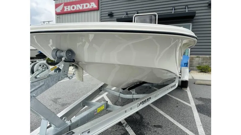 Slide: The Image of 2025 Carolina Skiff 21 LS boat on trailer, parked near Honda dealership. - 2