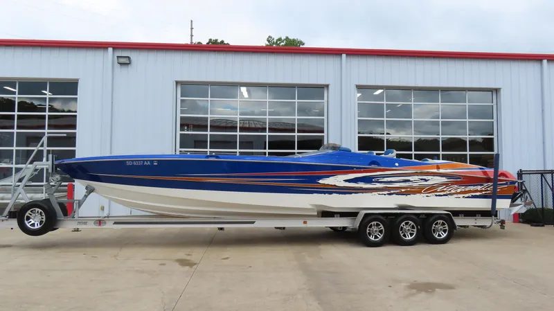 The Image of 2007 Cigarette 38 Top Gun speedboat on trailer, vibrant blue and orange design. - 0