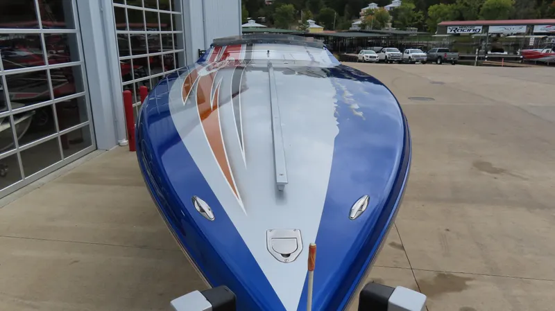 Slide: The Image of 2007 Cigarette 38 Top Gun speedboat with blue and orange design, parked outdoors. - 4
