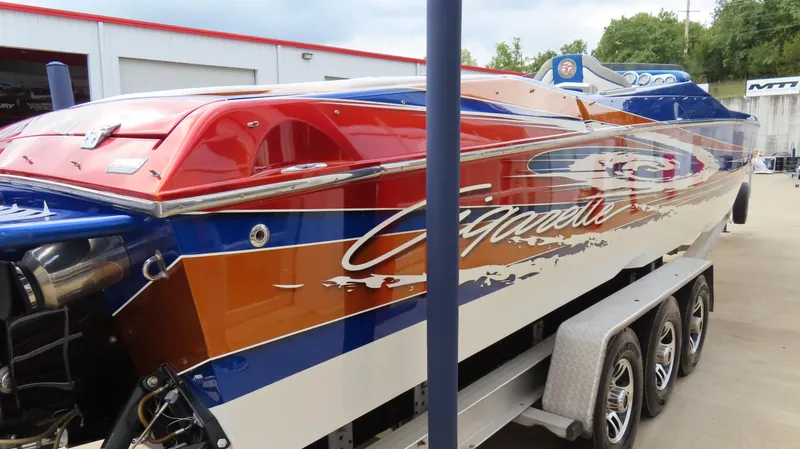 Slide: The Image of 2007 Cigarette 38 Top Gun speedboat with vibrant red, blue, and orange design on a trailer. - 6