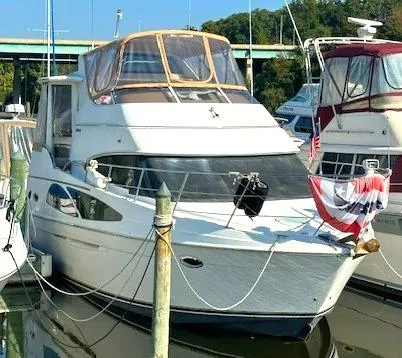 Slide: The Image of 2005 Carver 366 Motor Yacht docked at marina, featuring sleek design and festive decor. - 0