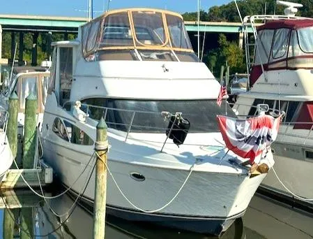 Slide: The Image of 2005 Carver 366 Motor Yacht docked at marina, adorned with patriotic bunting. - 2