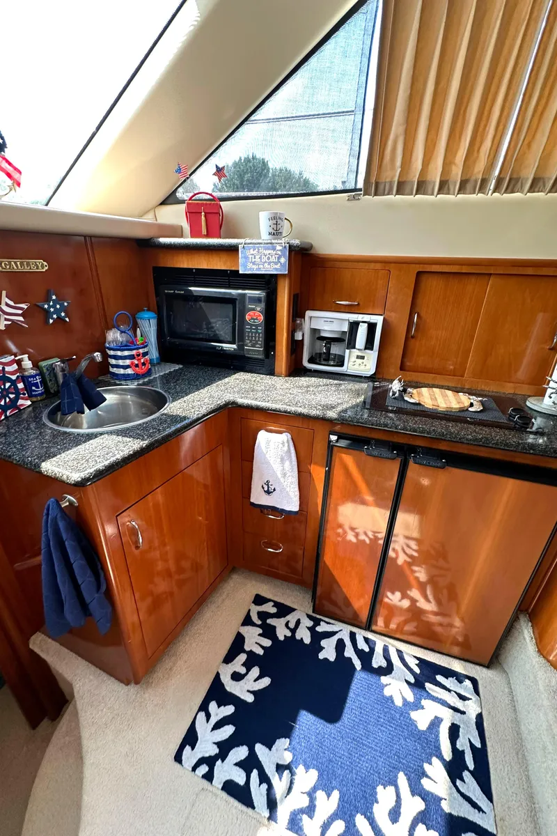 Slide: The Image of 2005 Carver 366 Motor Yacht kitchen with wood cabinets, microwave, and mini-fridge. - 22