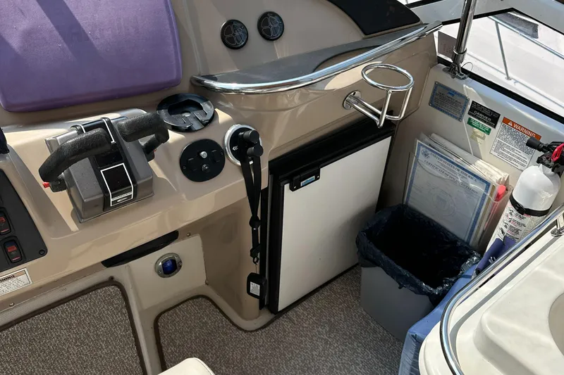 Slide: The Image of 2005 Carver 366 Motor Yacht helm with controls, mini fridge, and safety equipment. - 29