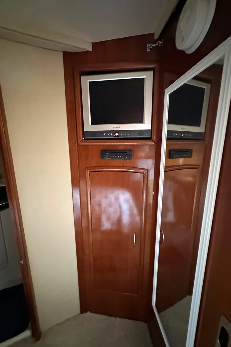 Slide: The Image of 2005 Carver 366 Motor Yacht interior with TV and mirrored cabinet. - 30