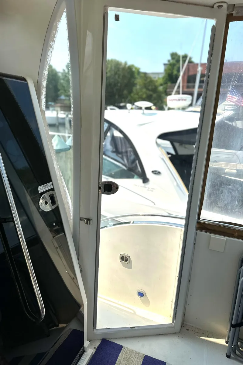 Slide: The Image of 2005 Carver 366 Motor Yacht interior with open door, revealing docked boats. - 38