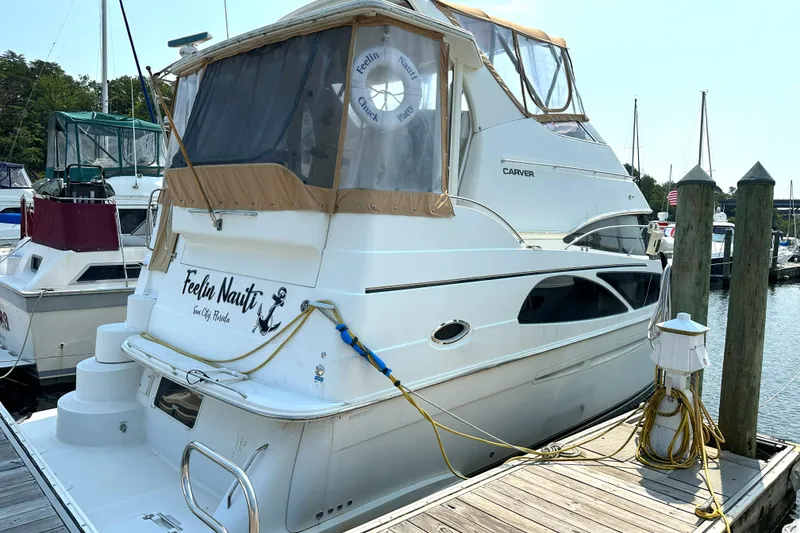 Slide: The Image of 2005 Carver 366 Motor Yacht docked at marina, featuring "Feelin Nauti" name on stern. - 4