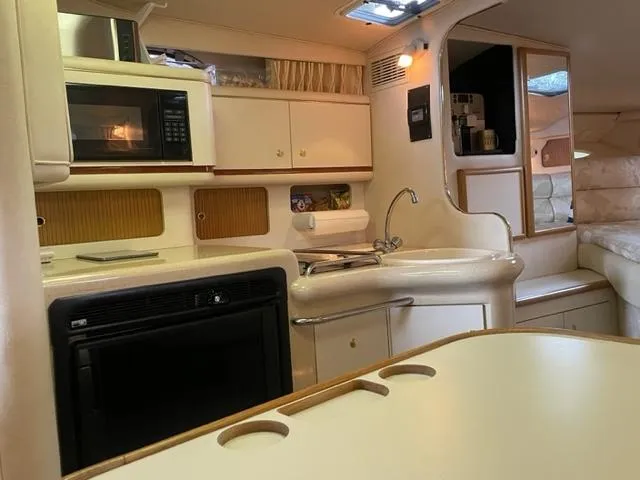 Slide: The Image of 1999 Sea Ray 330 Sundancer helm with Raymarine navigation system and wood-accented steering wheel. - 5