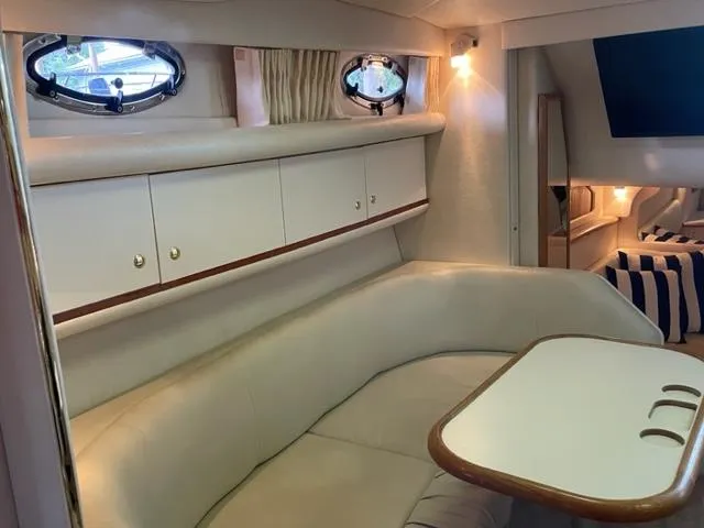 Slide: The Image of 1999 Sea Ray 330 Sundancer interior with mini fridge and seating. - 8