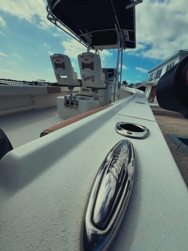 Slide: The Image of 2017 Parker 2801 Center Console boat with dual seats and canopy, docked under a blue sky. - 25