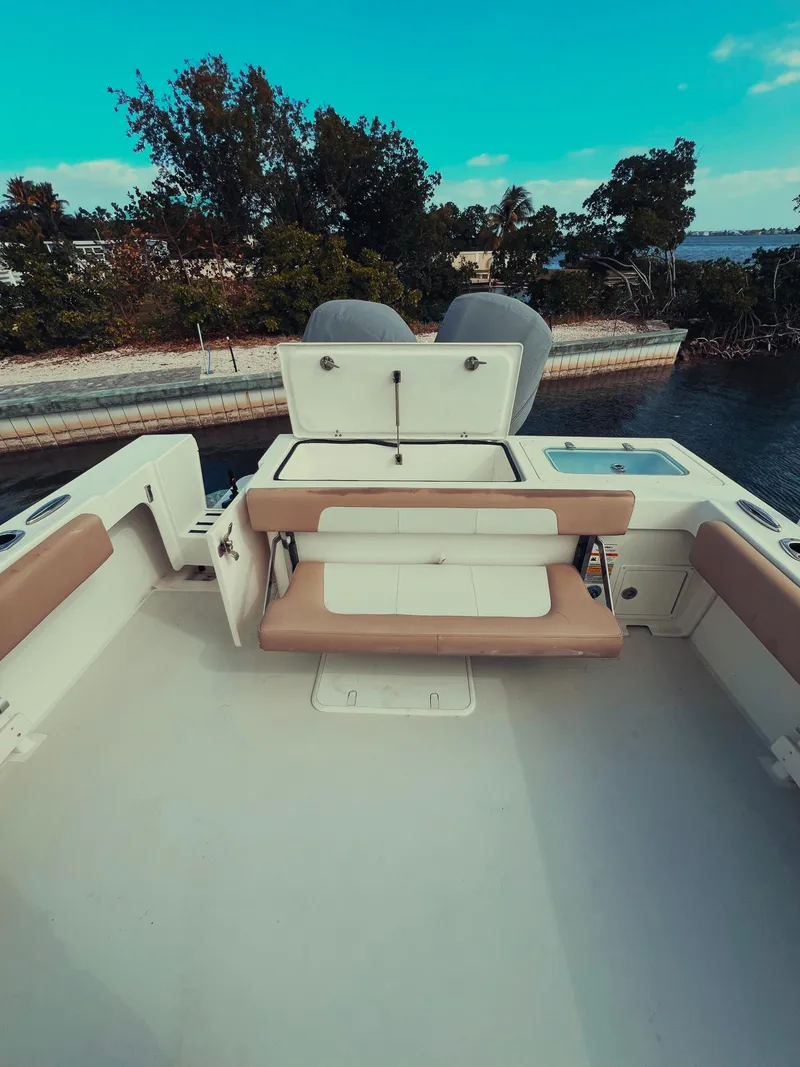 Slide: The Image of 2017 Parker 2801 Center Console boat with seating, docked near lush greenery. - 31