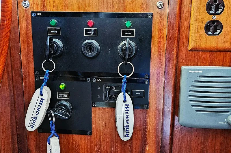 Slide: The Image of Control panel of a 2003 Menorquin 120 boat with labeled keys and switches. - 11