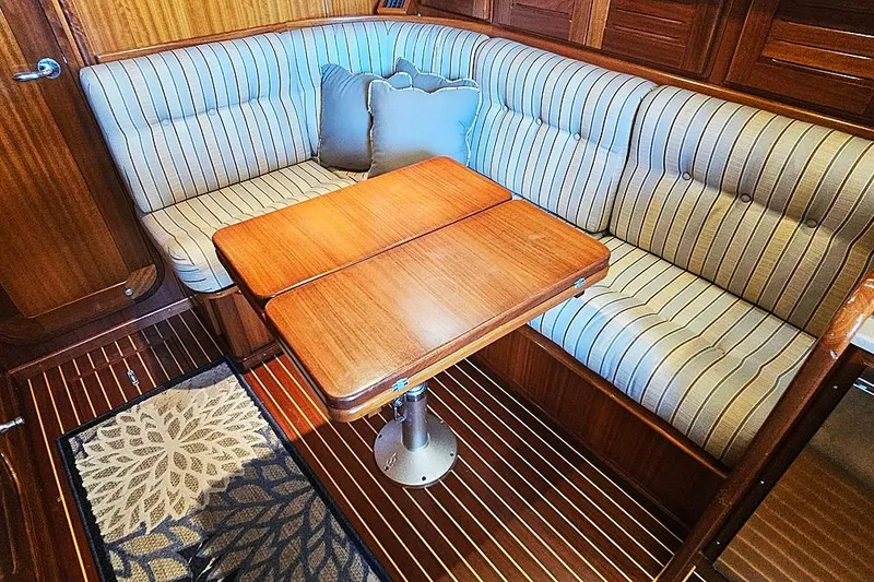 Slide: The Image of Cozy Menorquin 120 yacht interior with striped seating and wooden table, 2003 model. - 14