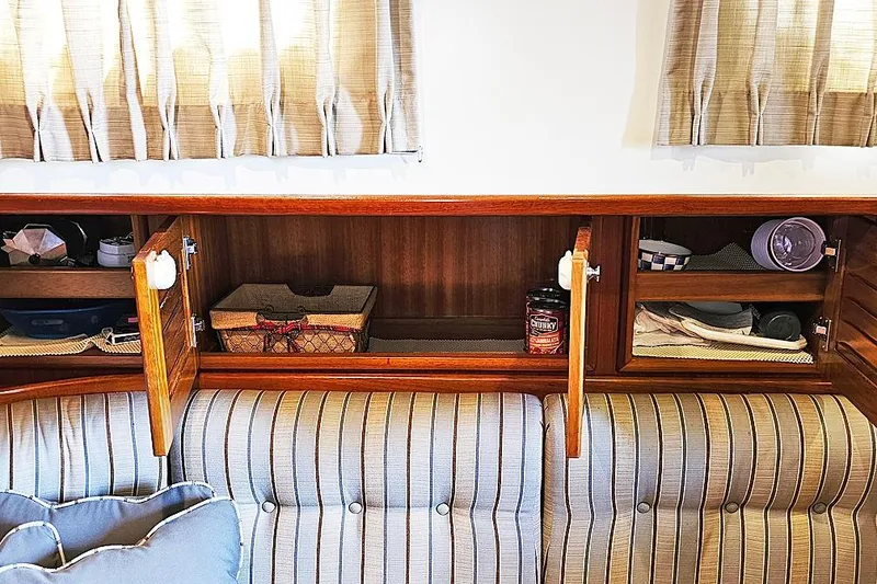 Slide: The Image of Interior of 2003 Menorquin 120 boat with striped seating and wooden storage cabinets. - 17