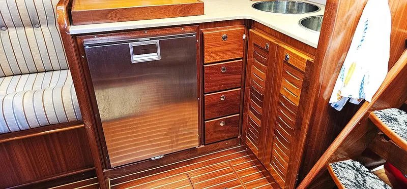 Slide: The Image of Interior of Menorquin 120 yacht kitchen, 2003 model, featuring wood cabinets and stainless steel appliances. - 21