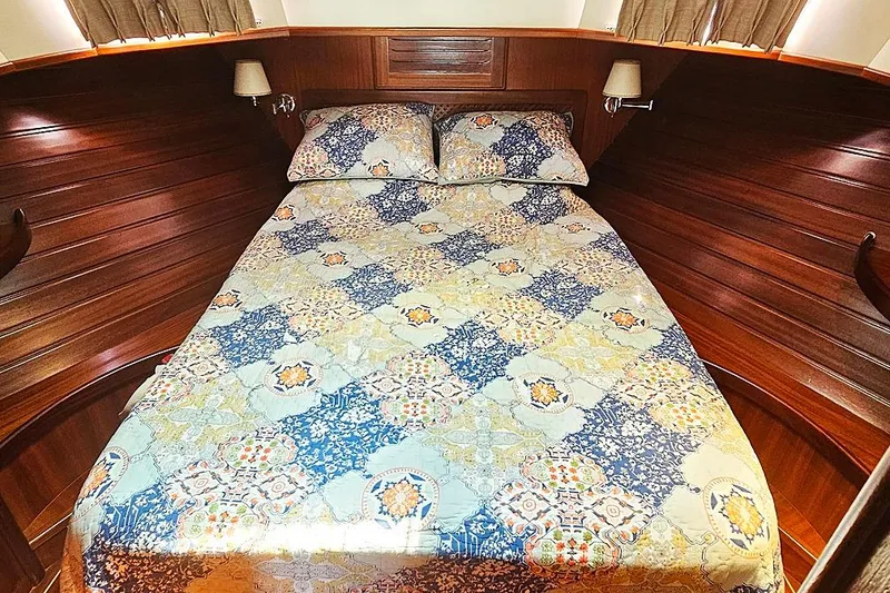 Slide: The Image of Cozy cabin bedroom in 2003 Menorquin 120 yacht with patterned bedding and wooden interior. - 24