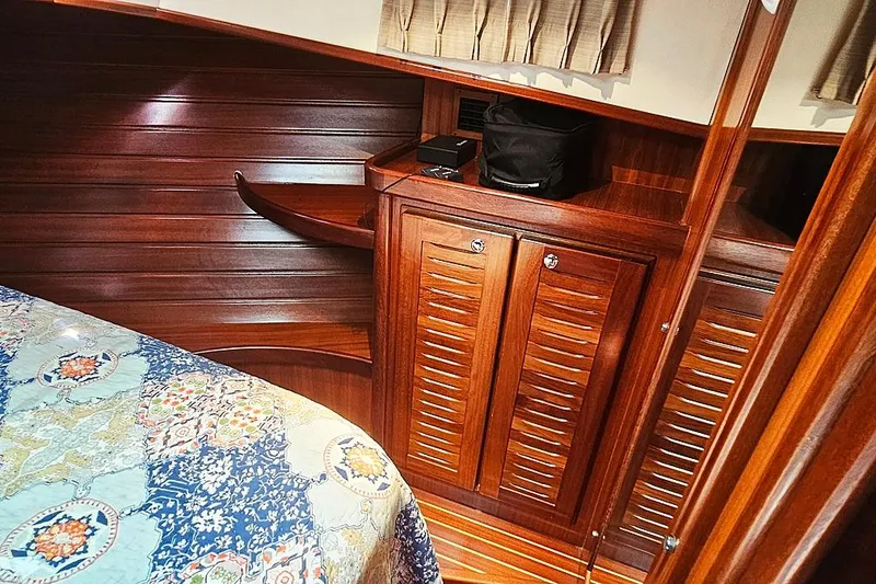 Slide: The Image of Luxurious wooden interior of a 2003 Menorquin 120 yacht cabin with patterned bedding. - 25