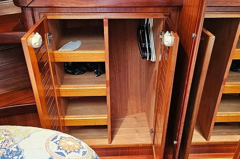 Slide: The Image of Wooden cabinet interior on a 2003 Menorquin 120 boat, featuring shelves and hangers. - 26