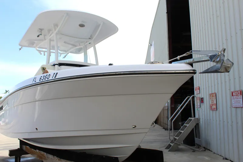 Slide: The Image of 2022 Century 2200 Center Console boat docked near a warehouse. - 12